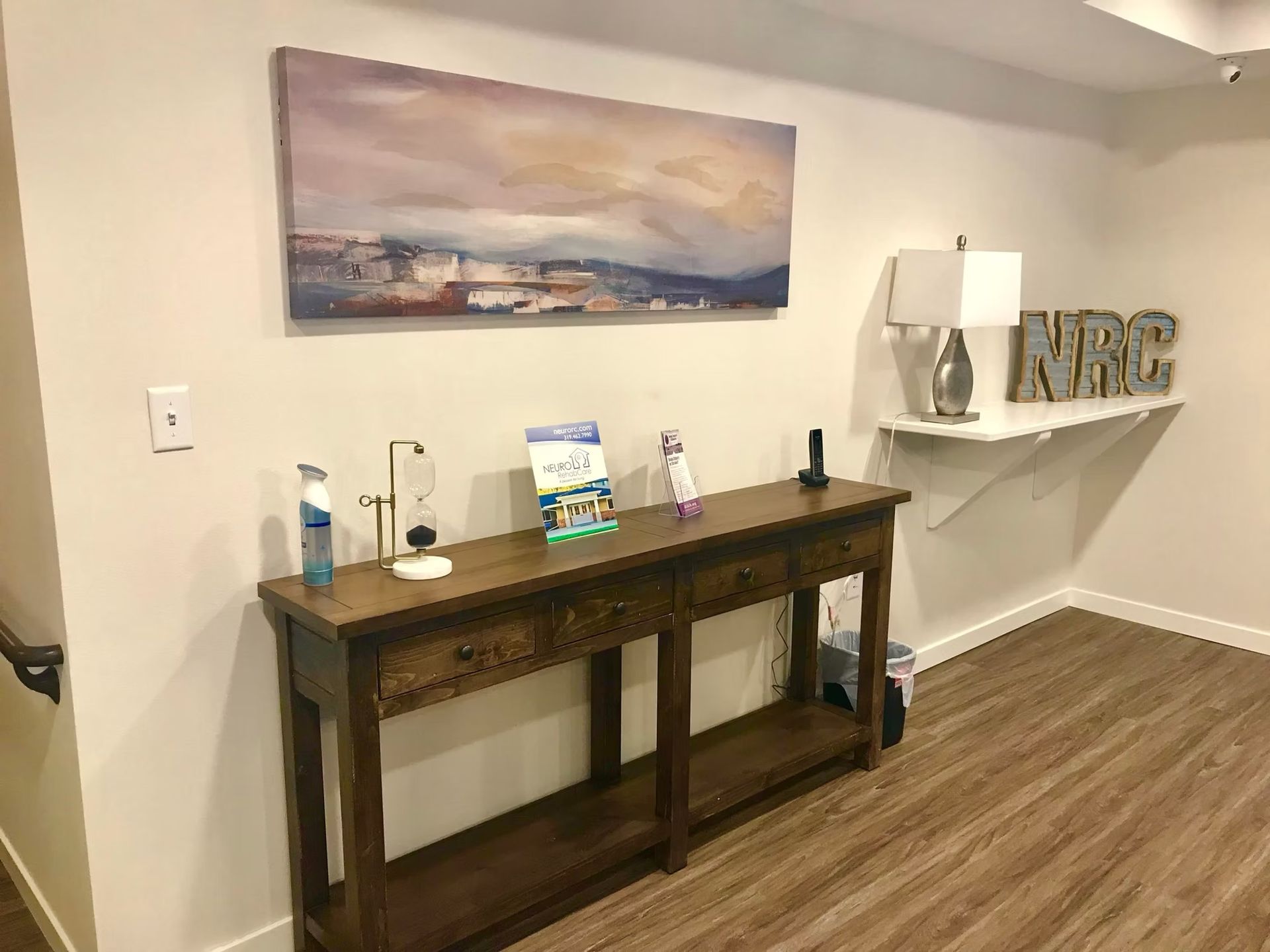 A hallway with a wooden table and a painting on the wall.