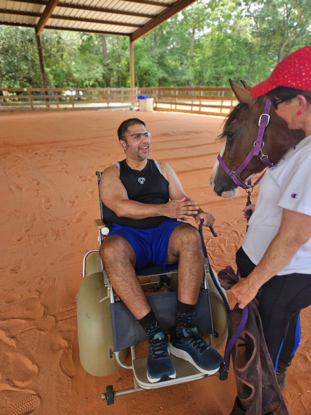 A man in a wheelchair is being led by a horse.
