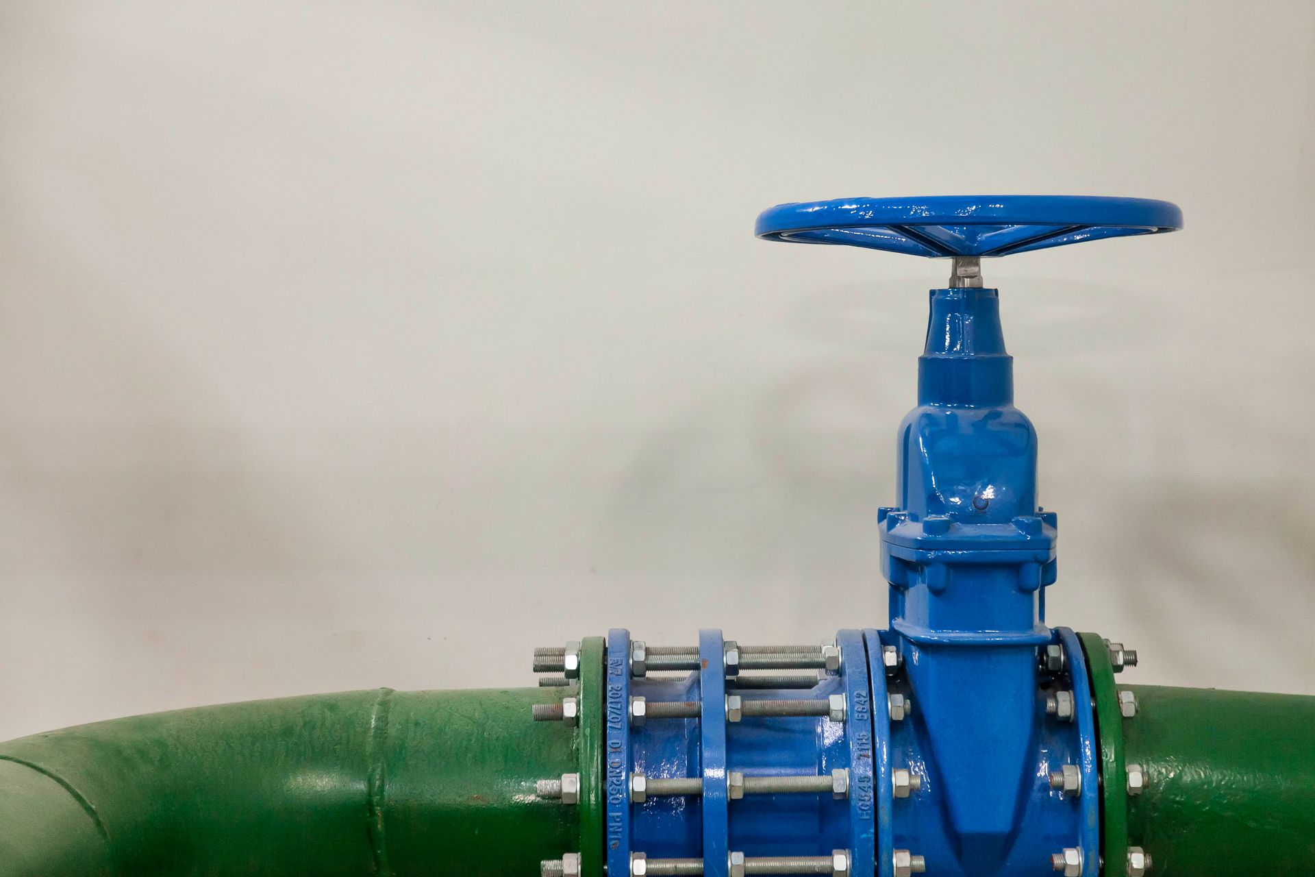 a blue valve is sitting on top of a green pipe .