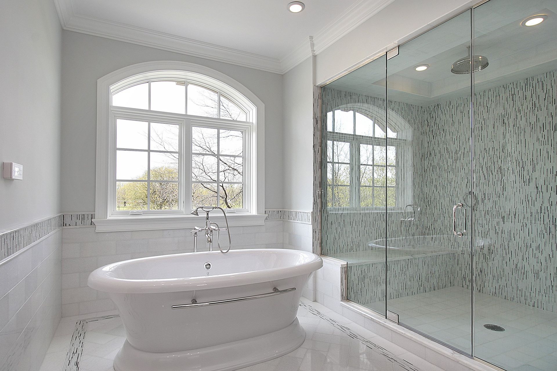 a bathroom with a tub , shower and window .