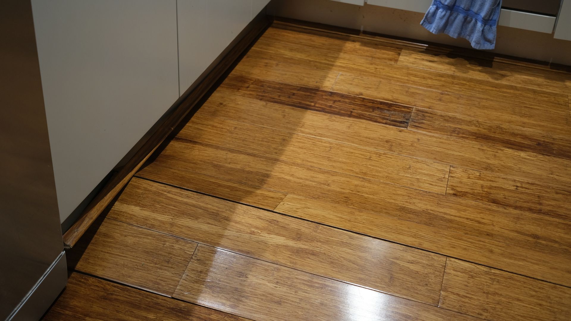 A close up of a wooden floor in a kitchen.