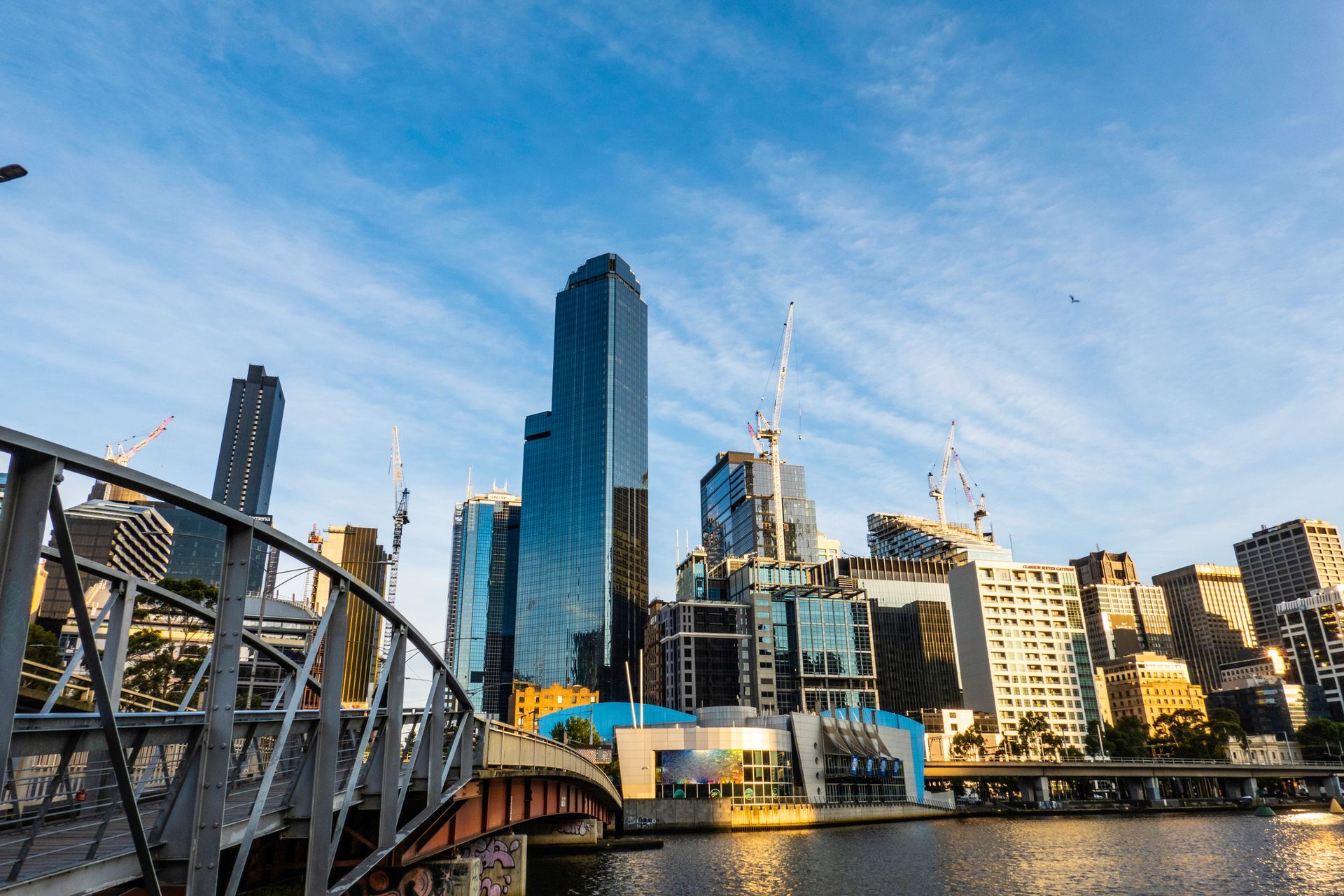 A bridge over a river with a city skyline in the background.