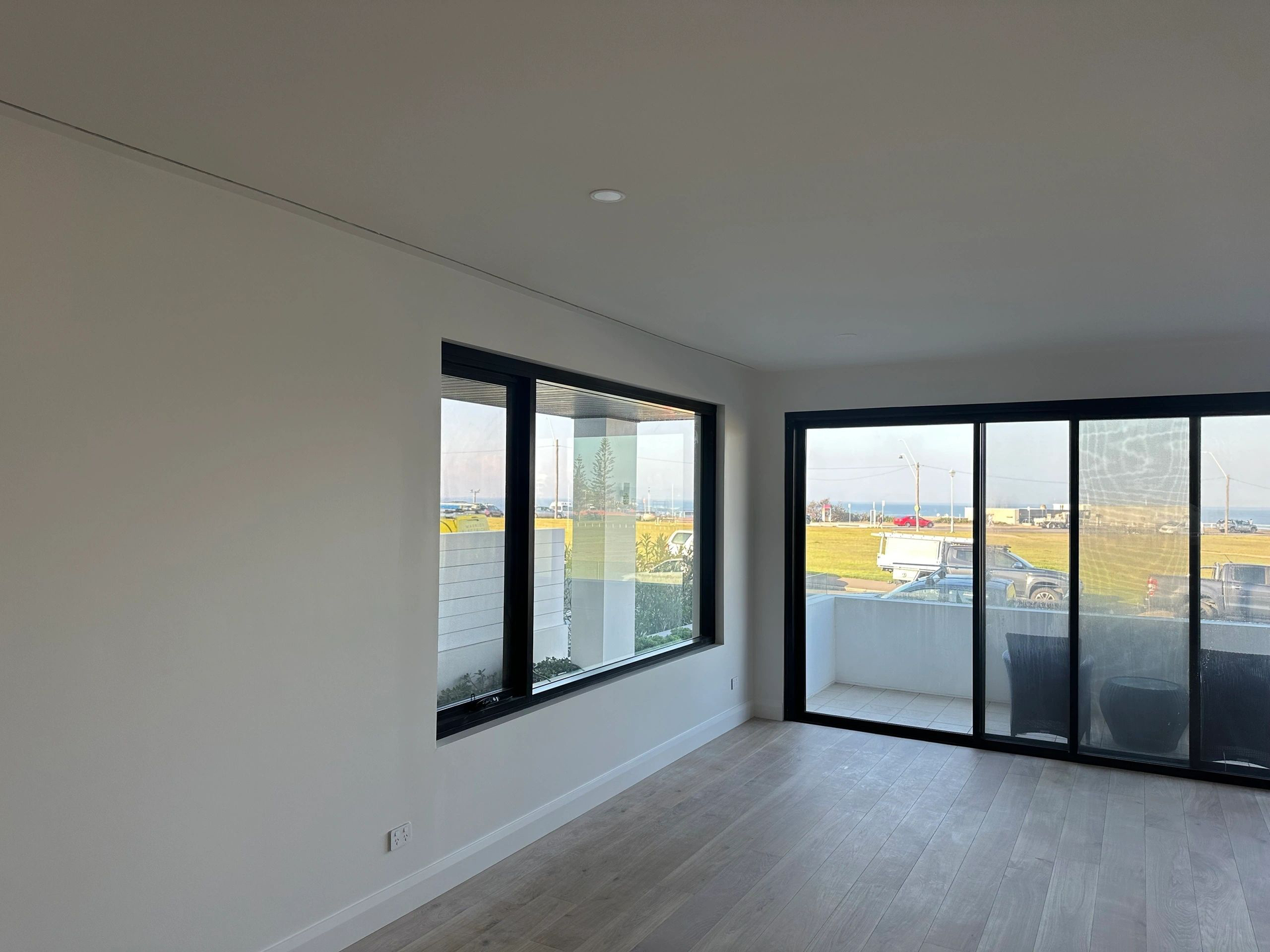 An empty living room with a balcony and sliding glass doors