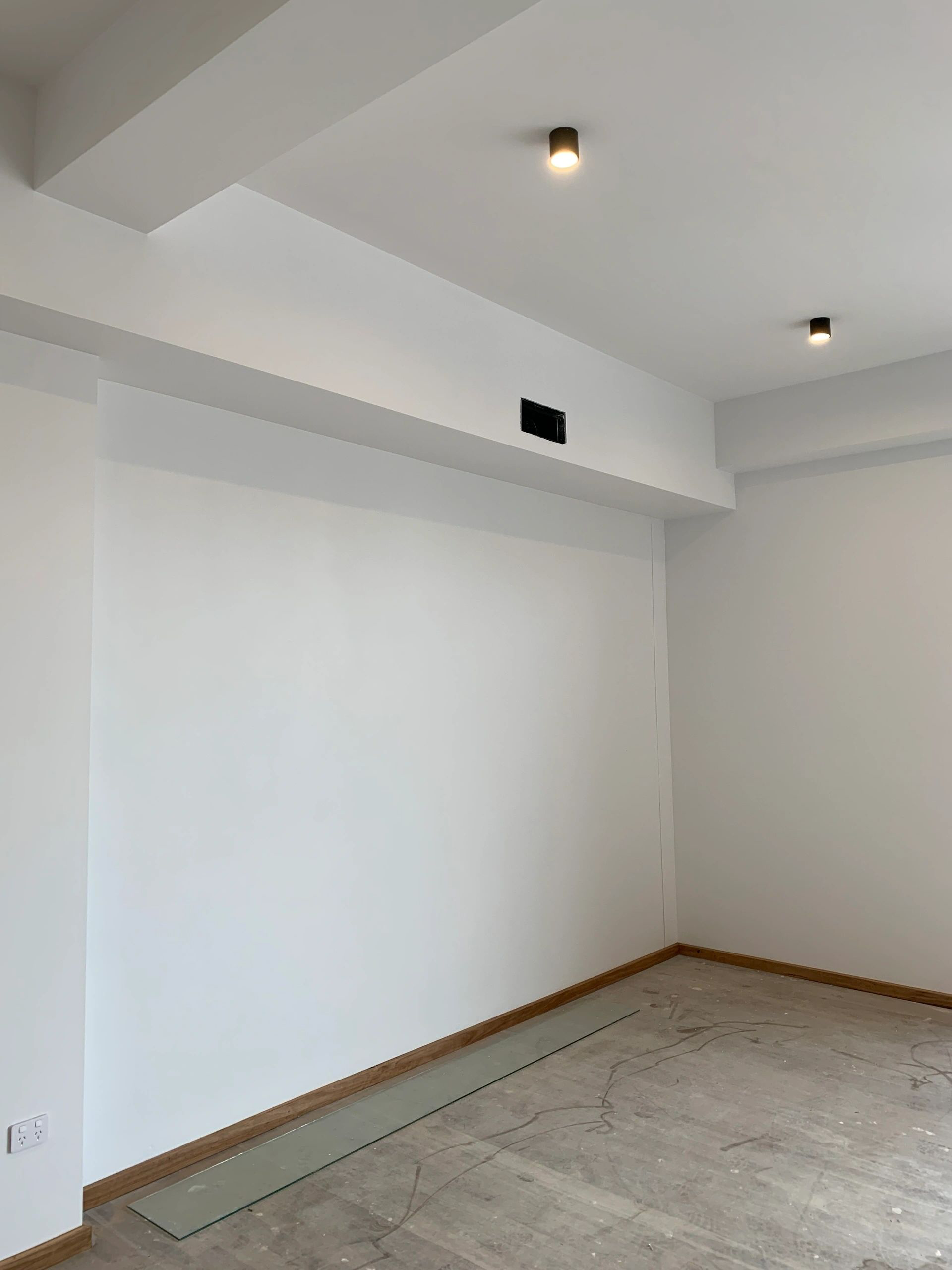 An empty room with white walls and a wooden floor