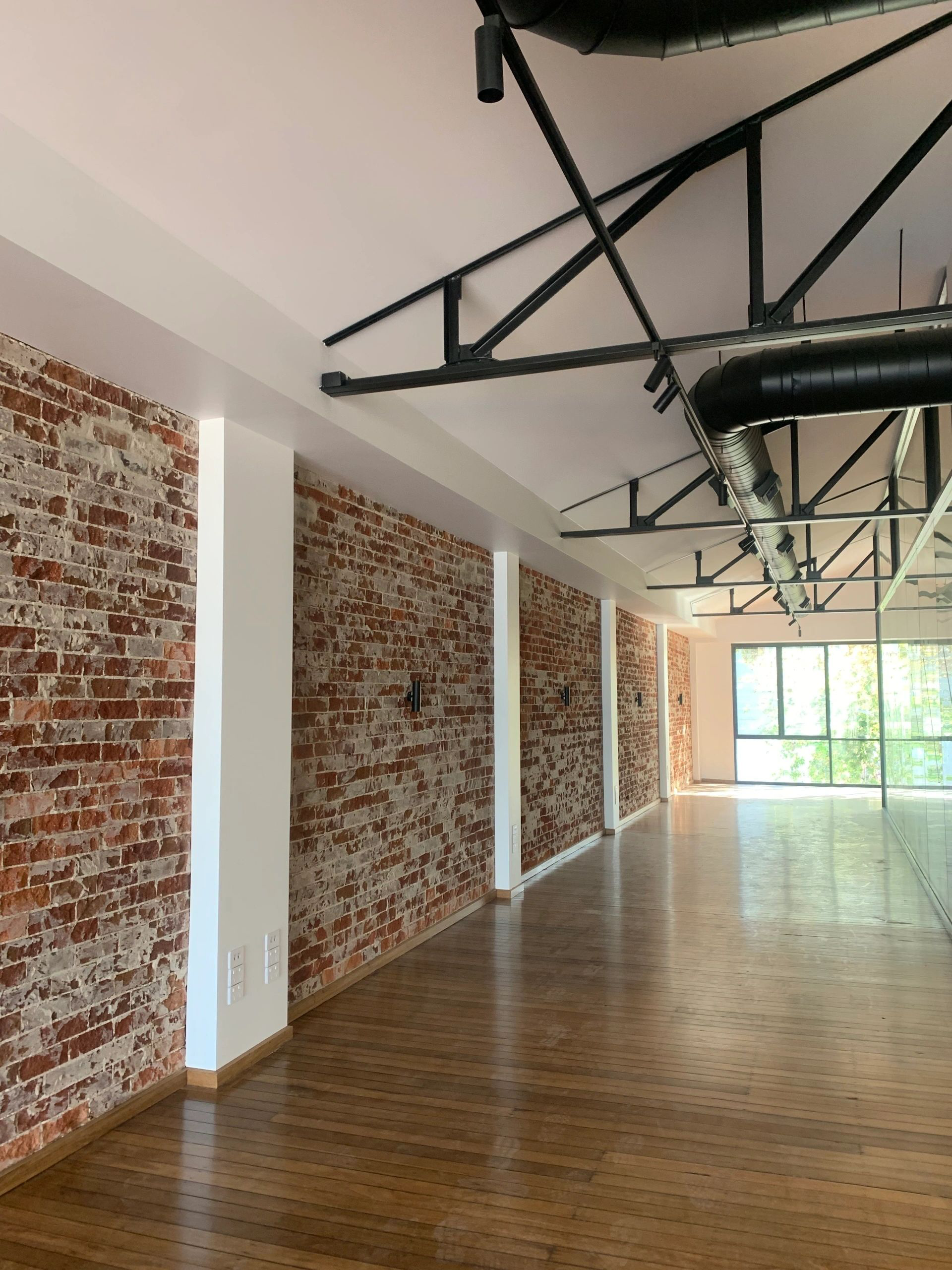 An empty room with brick walls and wooden floors
