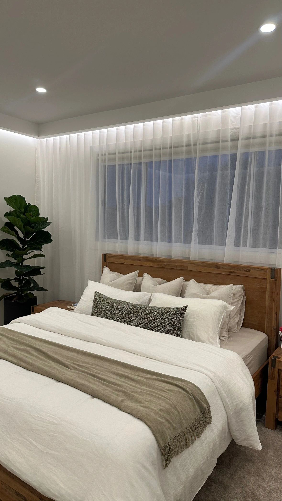 A bedroom with a large bed and a window.