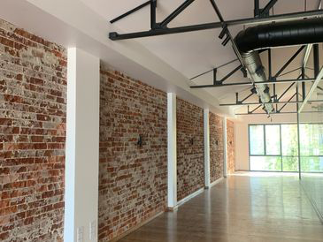 An empty room with brick walls and wooden floors