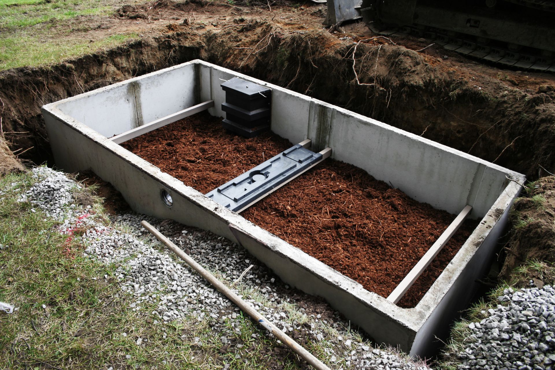 A large concrete box filled with dirt and gravel