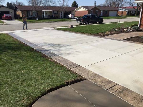 A concrete driveway with a truck parked on the side of it