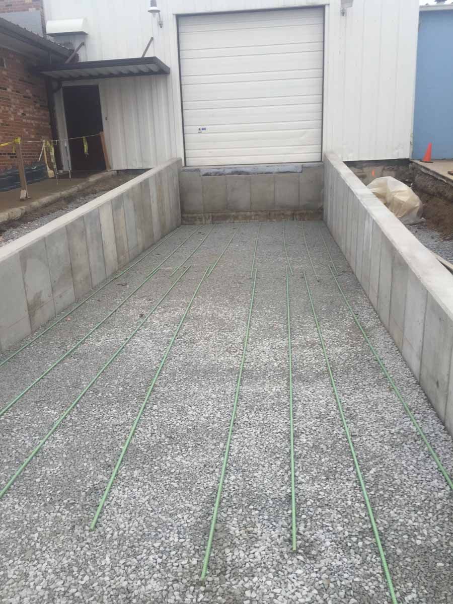 A concrete driveway is being built in front of a building.