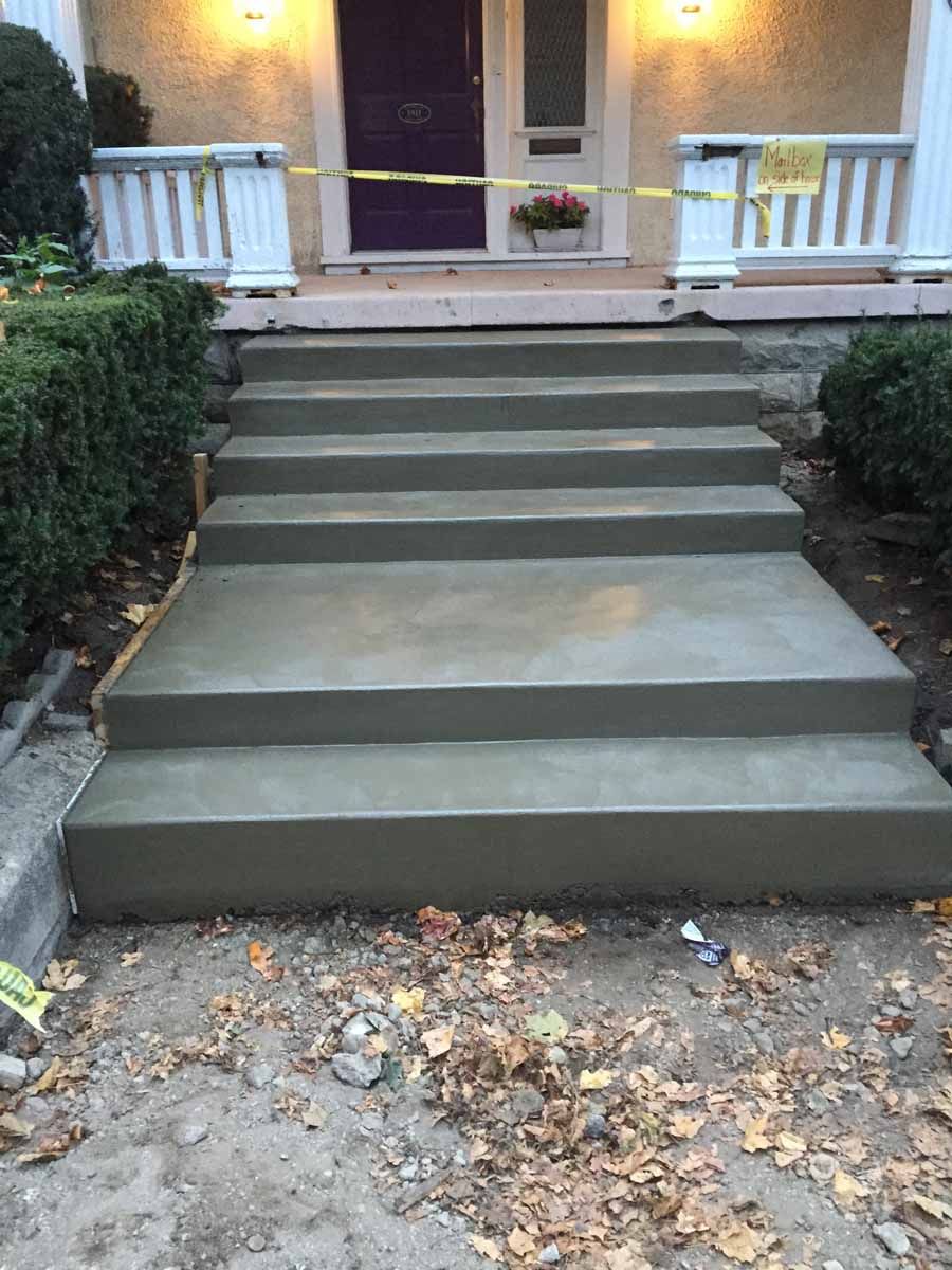 A set of concrete steps leading up to a house.