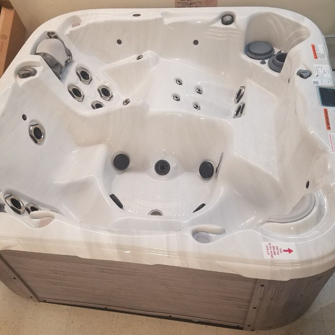 A large white hot tub is sitting on the floor