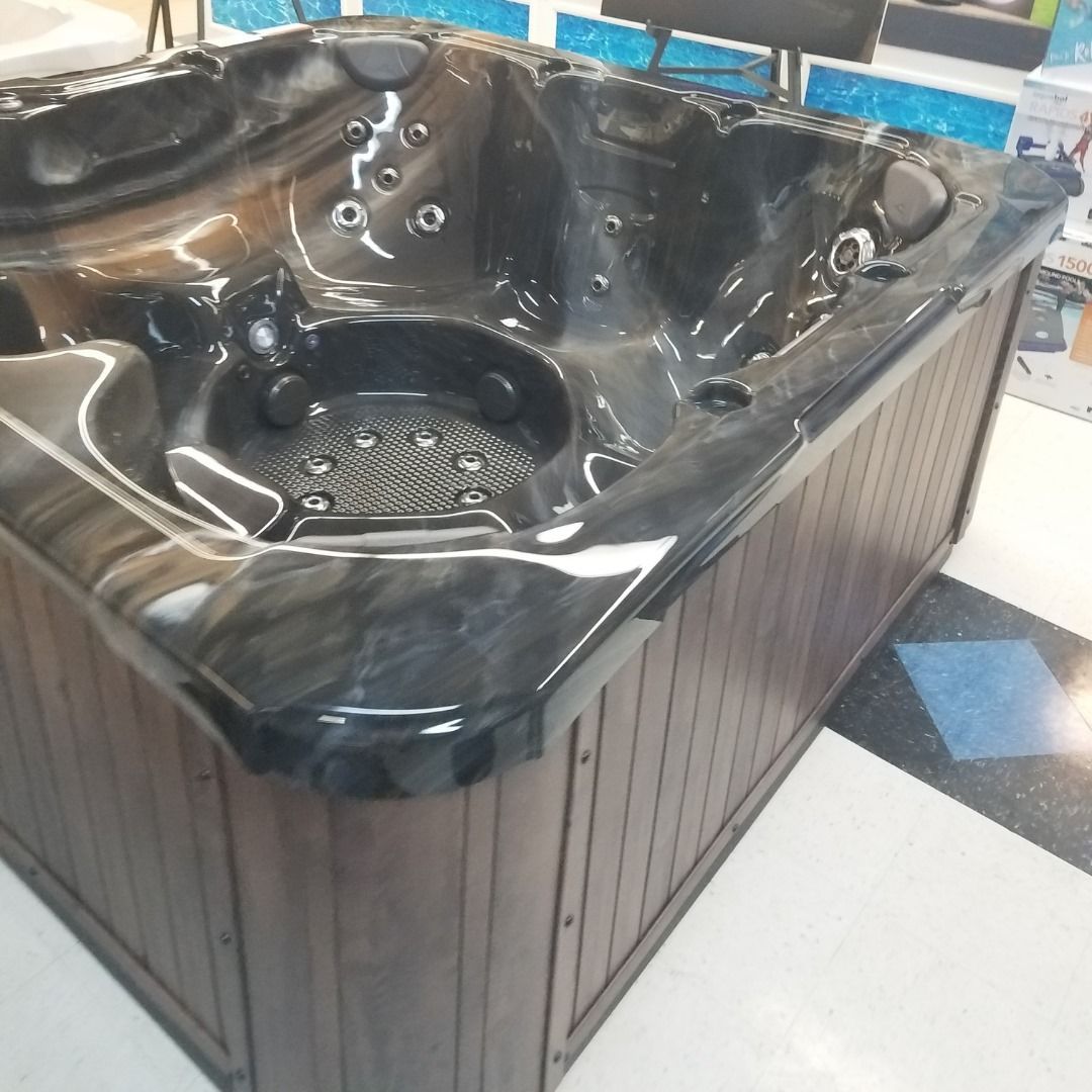 A large black hot tub with a wooden base