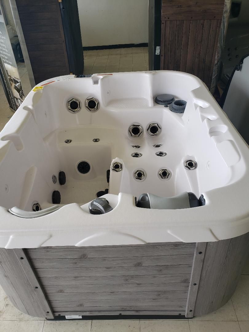 A white hot tub is sitting on the floor in a room.