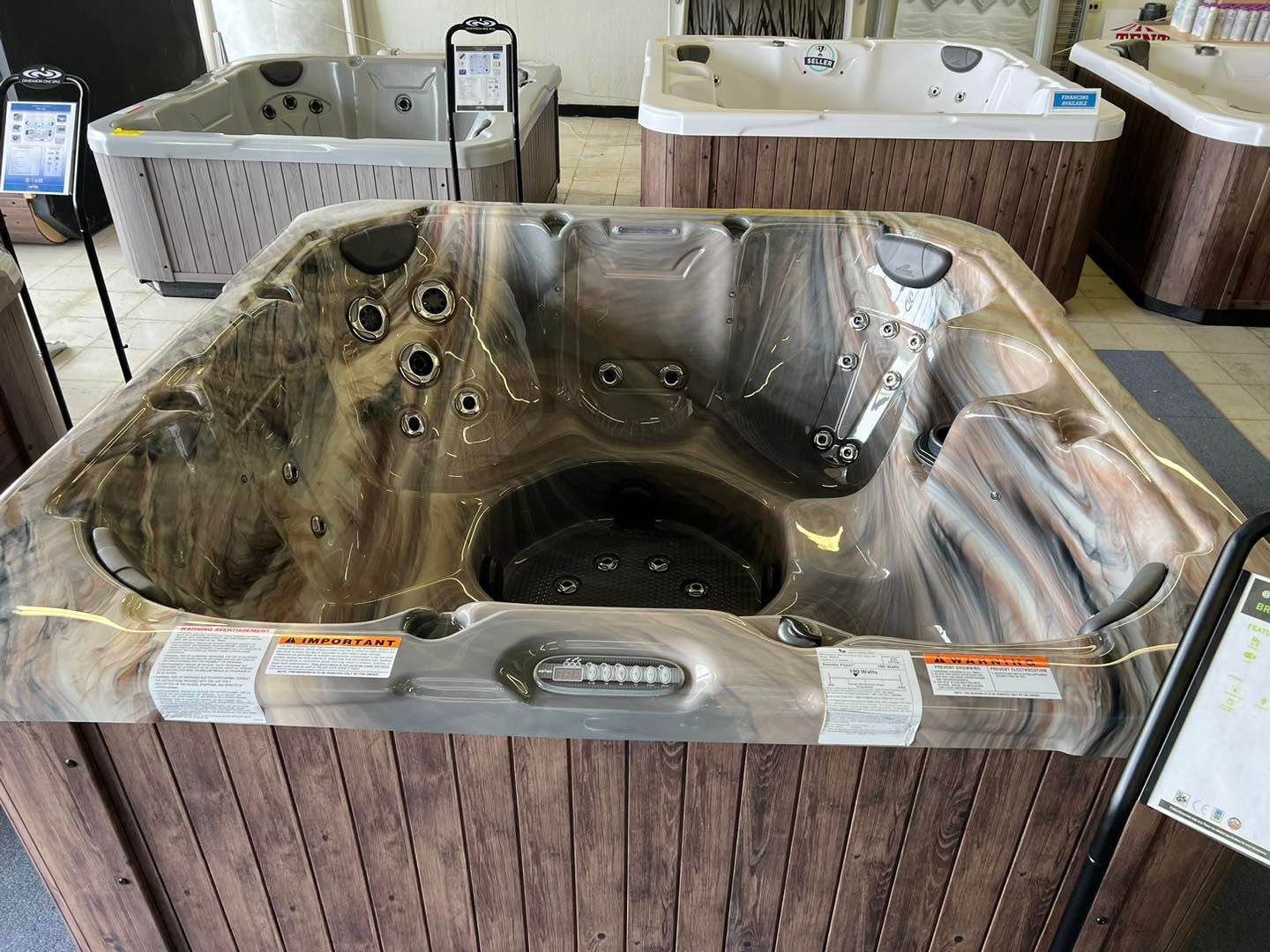 A hot tub is sitting on top of a wooden table in a showroom.