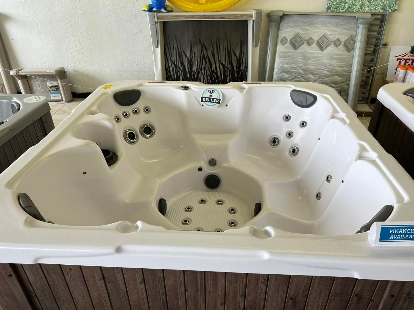 A white hot tub is sitting in a room next to a fireplace.