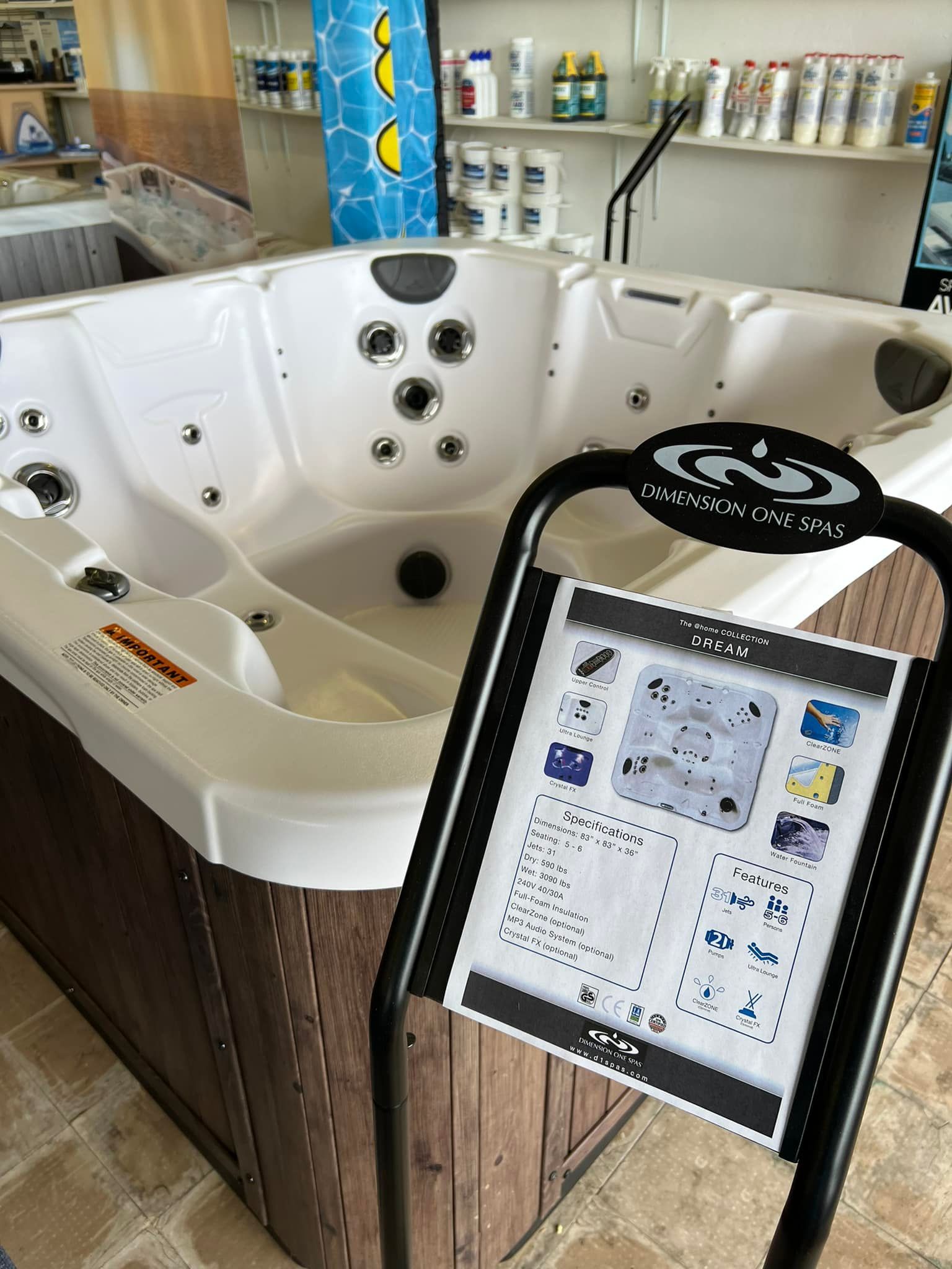 A hot tub is sitting next to a sign in a store.