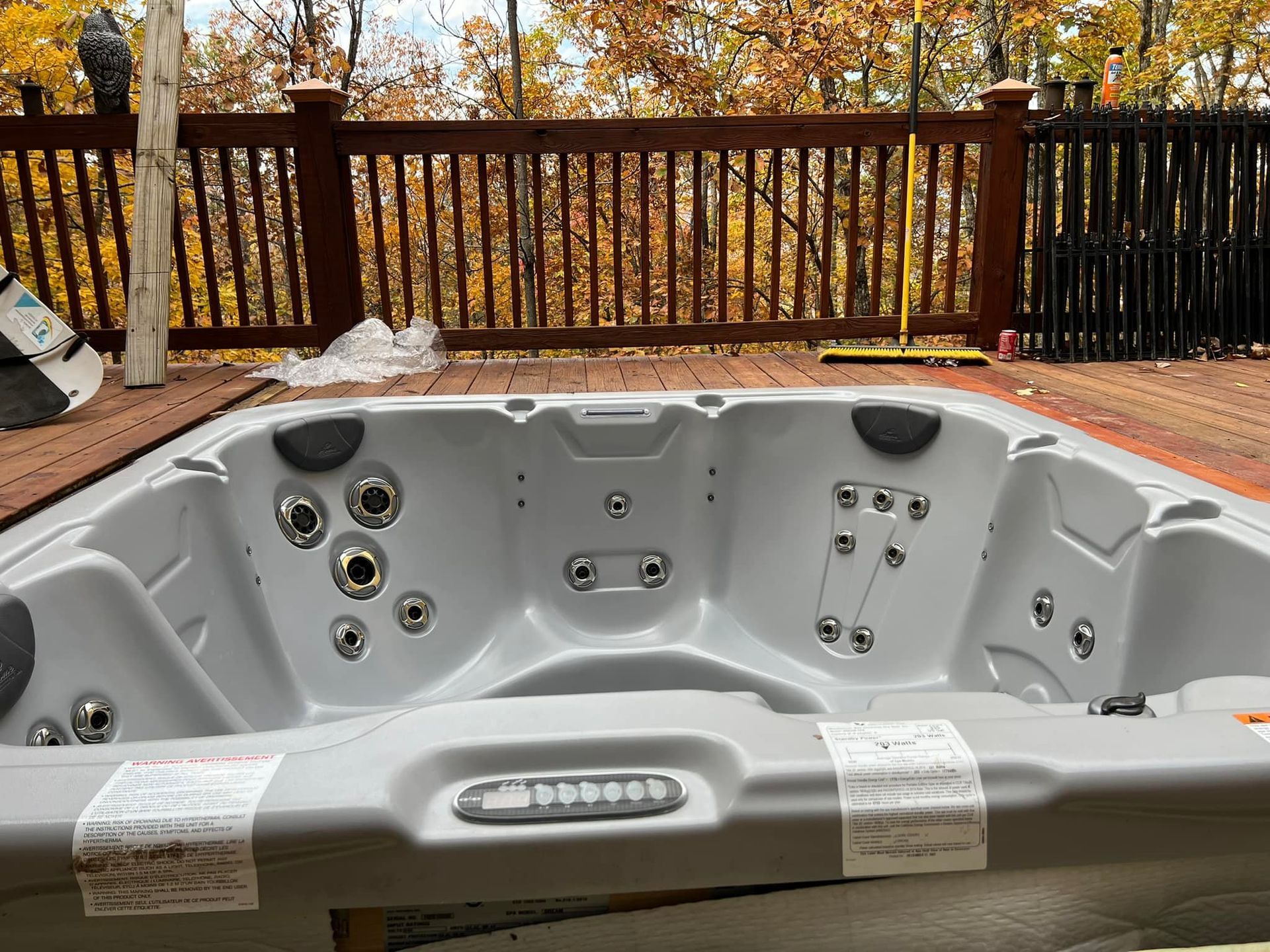 A hot tub is sitting on top of a wooden deck.