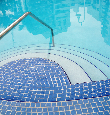 Stairs leading up to a swimming pool with blue tiles