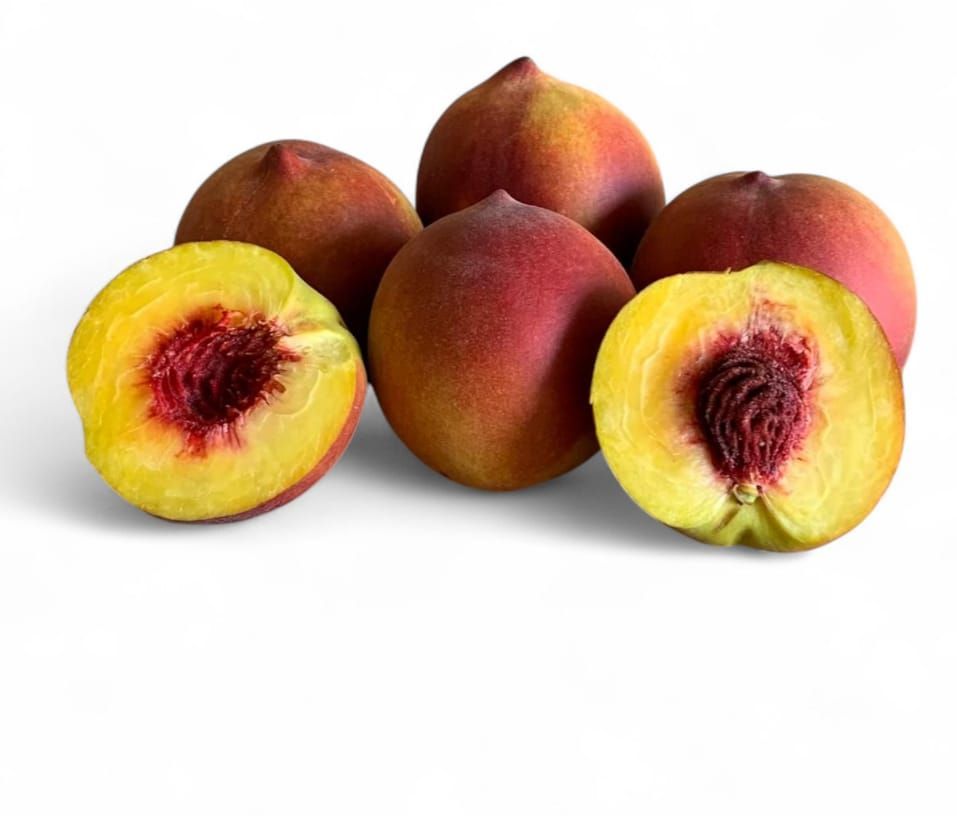 Pila de nectarinas maduras con hojas verdes, sobre un fondo marrón.