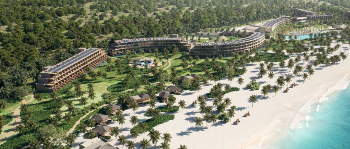 An aerial view of a beach resort surrounded by trees and palm trees.