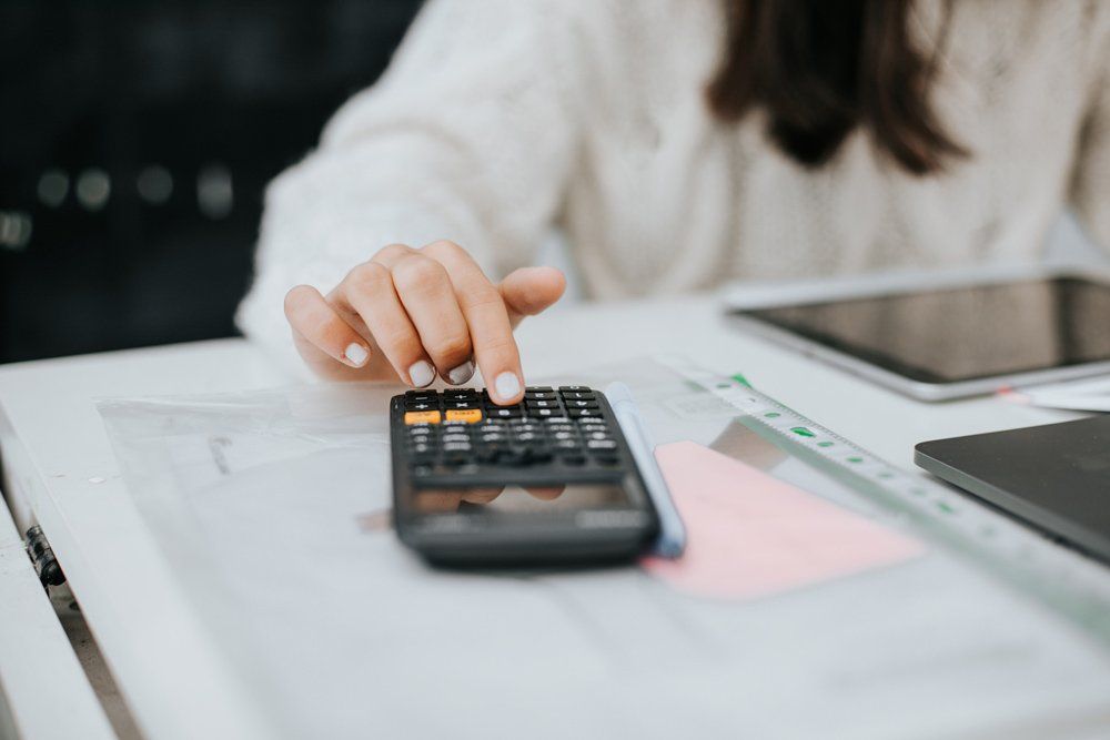 Woman Computing Budget With Calculator — Scottsdale, AZ — J.B. Martin Insurance Agencies