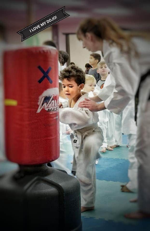 Instructor coaching a child one-on-one in a sensory-friendly dojo