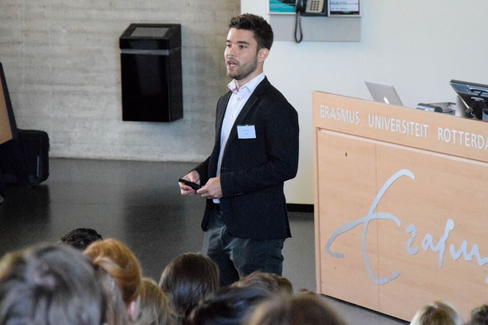 A man in a suit is giving a presentation to a group of people.