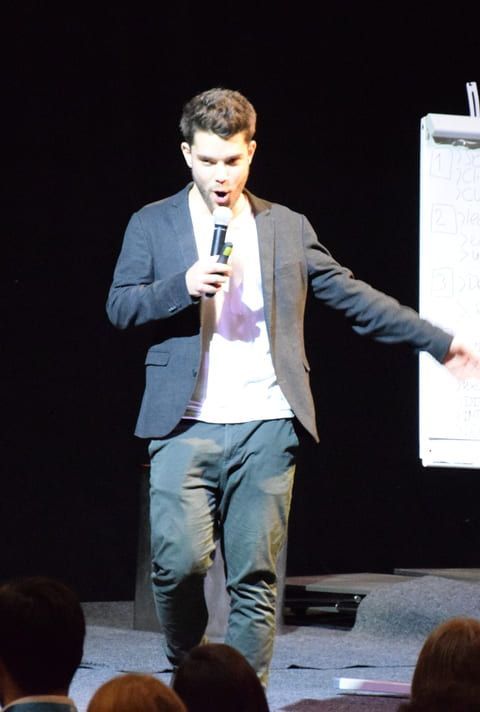 A man in a suit is speaking into a microphone