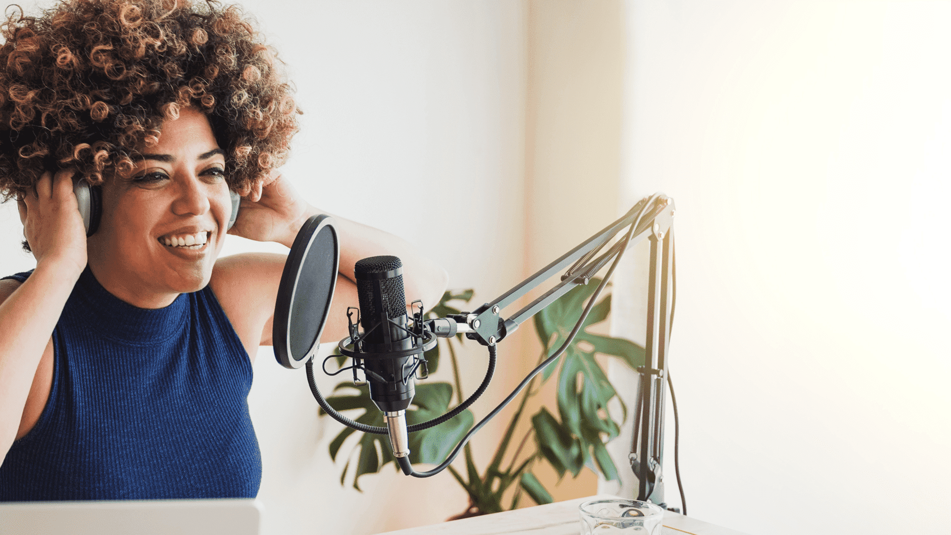 A woman is wearing headphones and singing into a microphone.