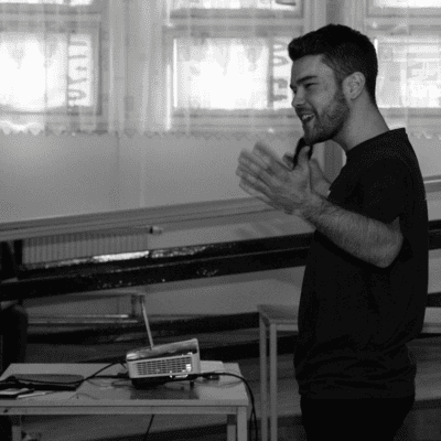 a man is giving a presentation to a group of people in a room .