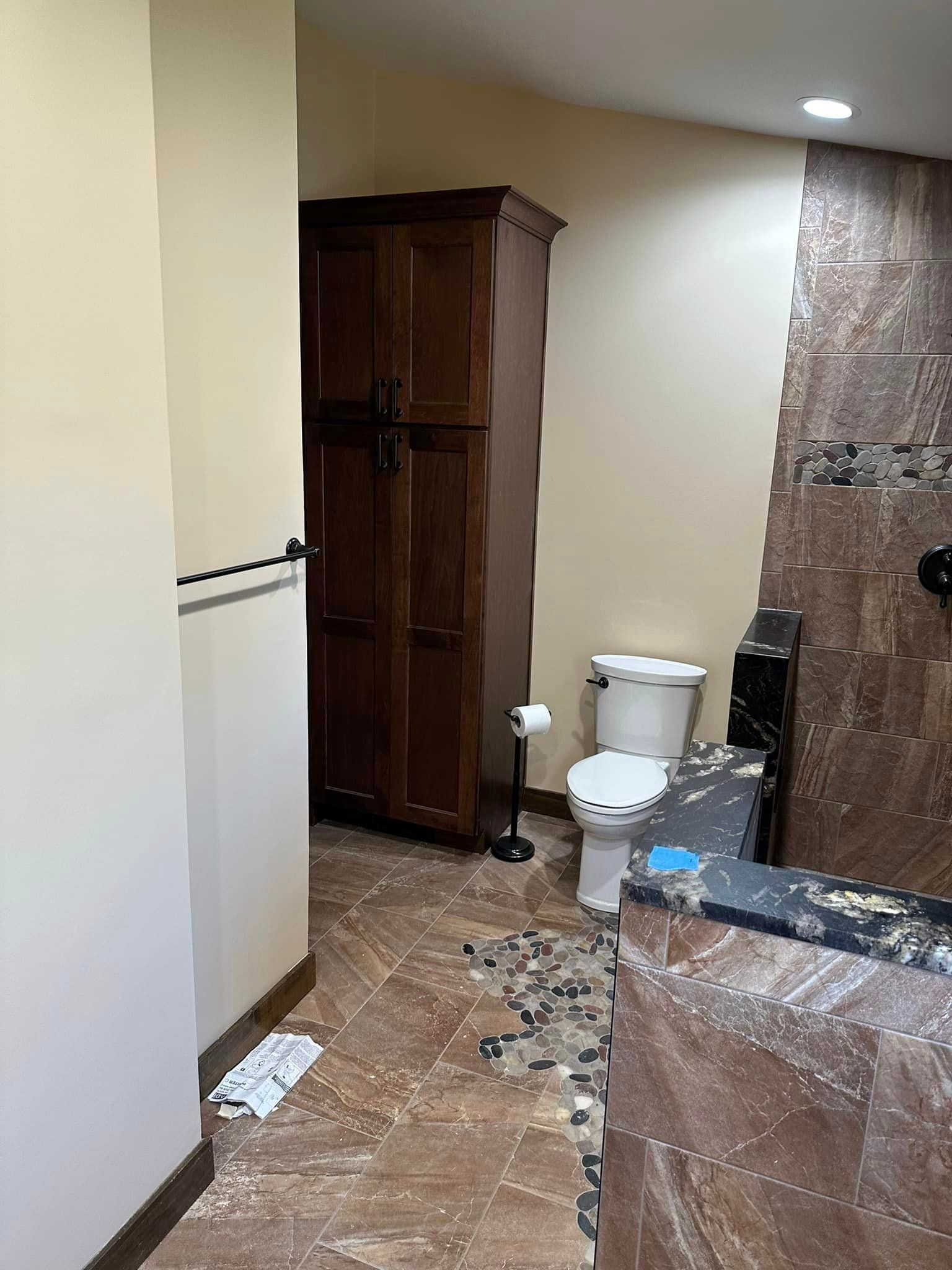 a bathroom with a toilet , sink , and cabinet .