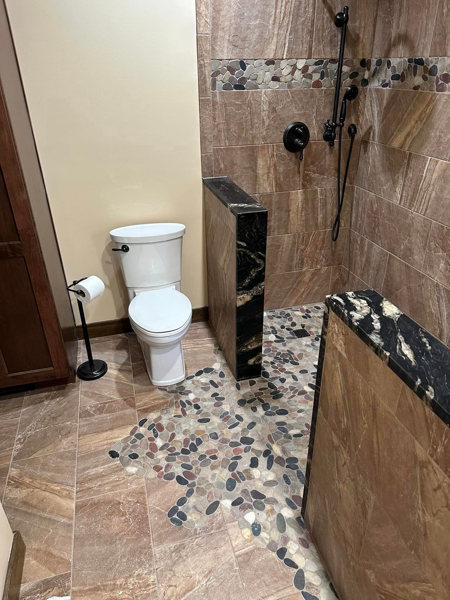 a bathroom with a toilet and a walk in shower .