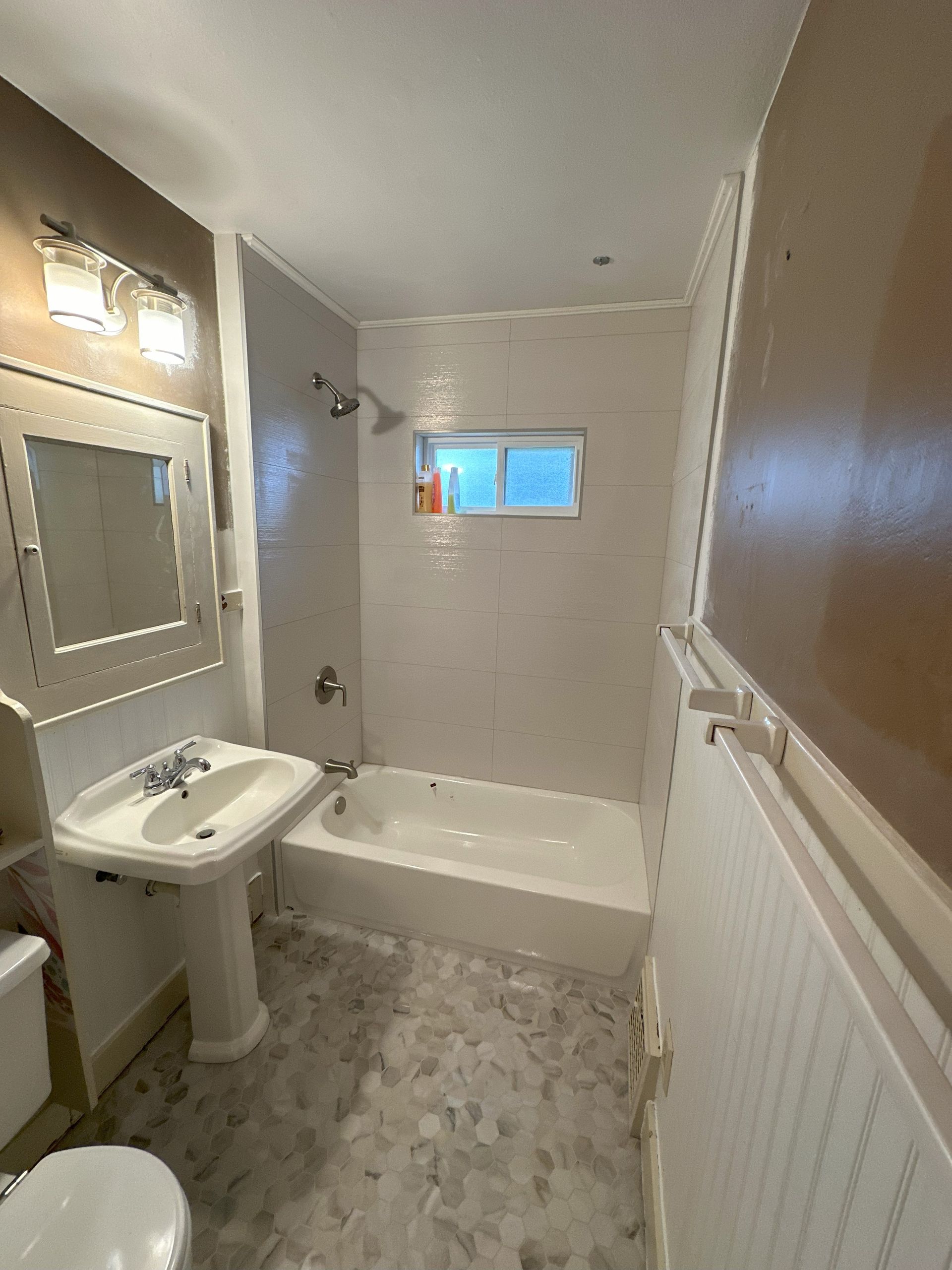 a bathroom with a tub , sink , toilet and mirror .