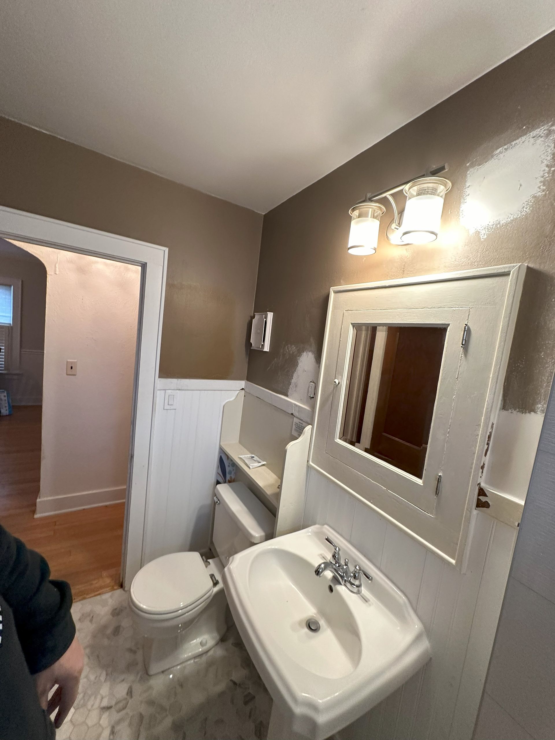 a bathroom with a sink , toilet and mirror