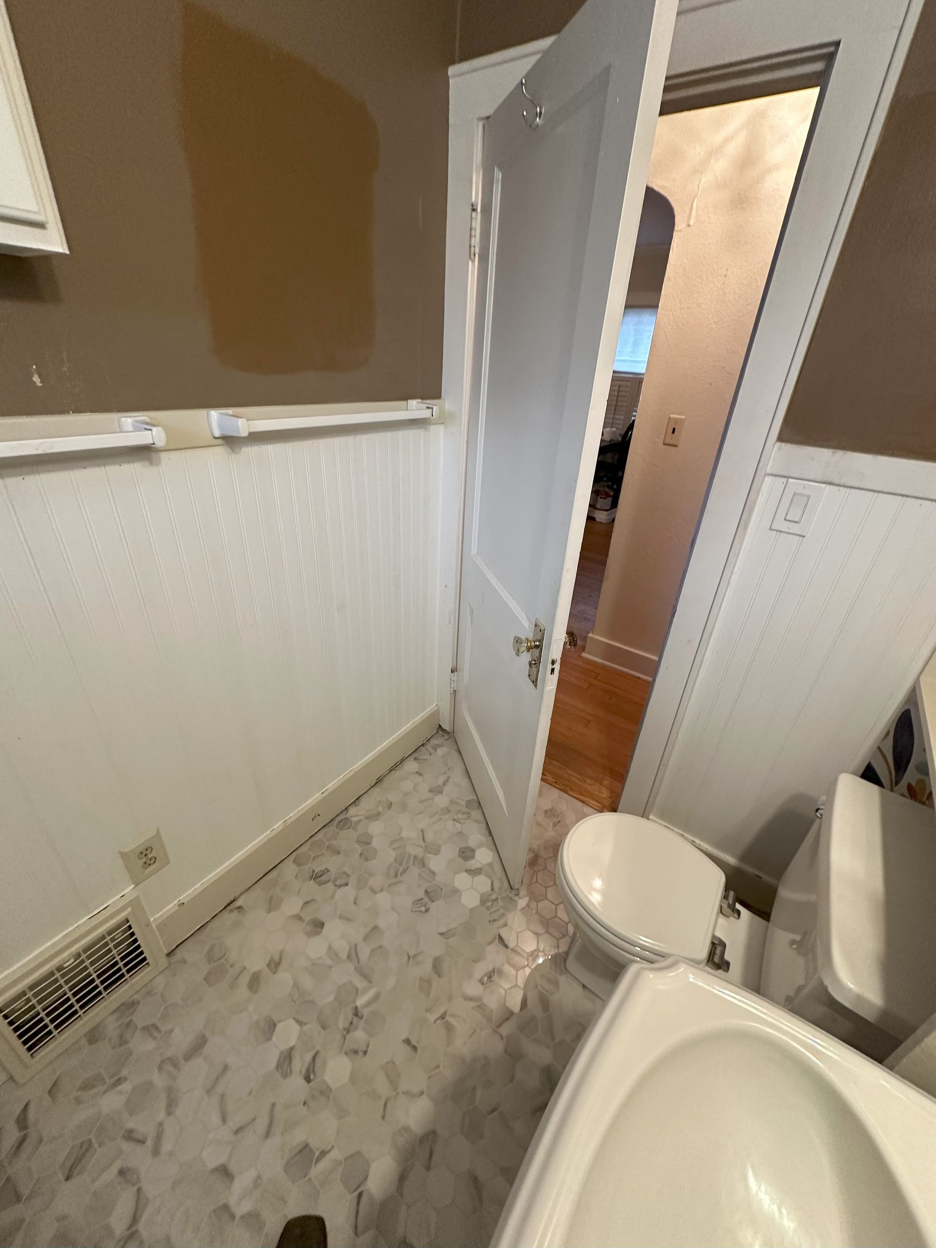 a bathroom with a toilet , sink , and door .