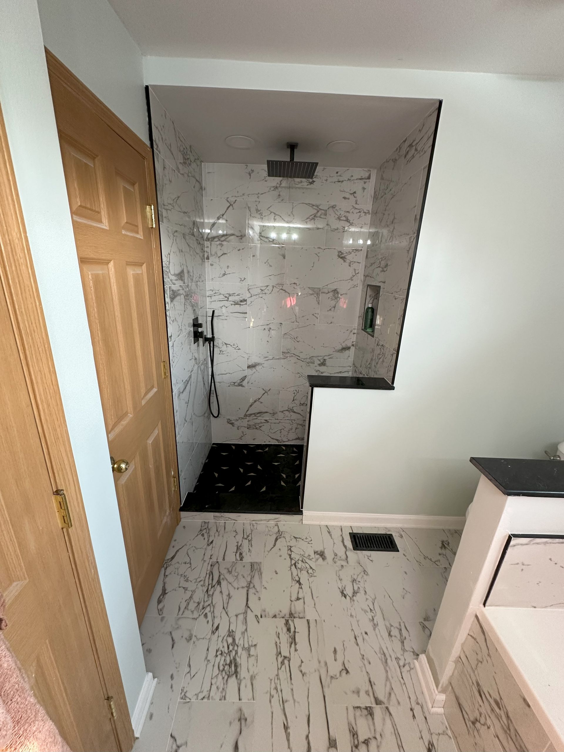 a bathroom with a walk in shower and a wooden door