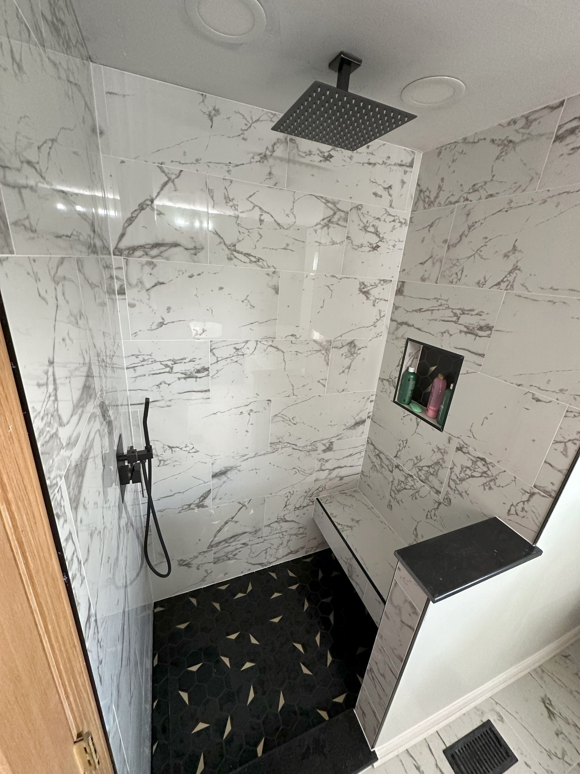 a bathroom with a walk in shower and a ceiling shower head .