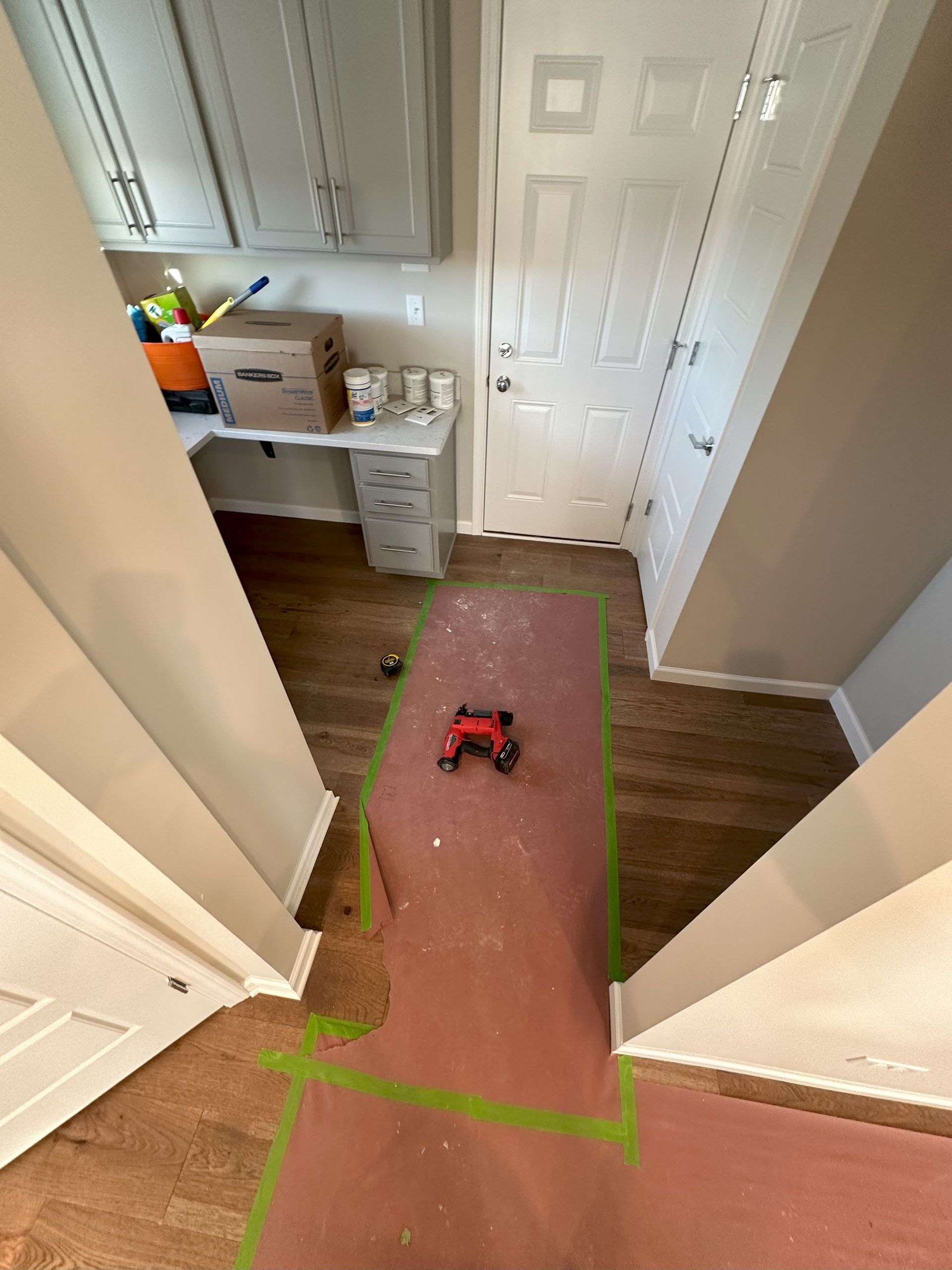 a room with a green tape on the floor and a red tool on the floor .