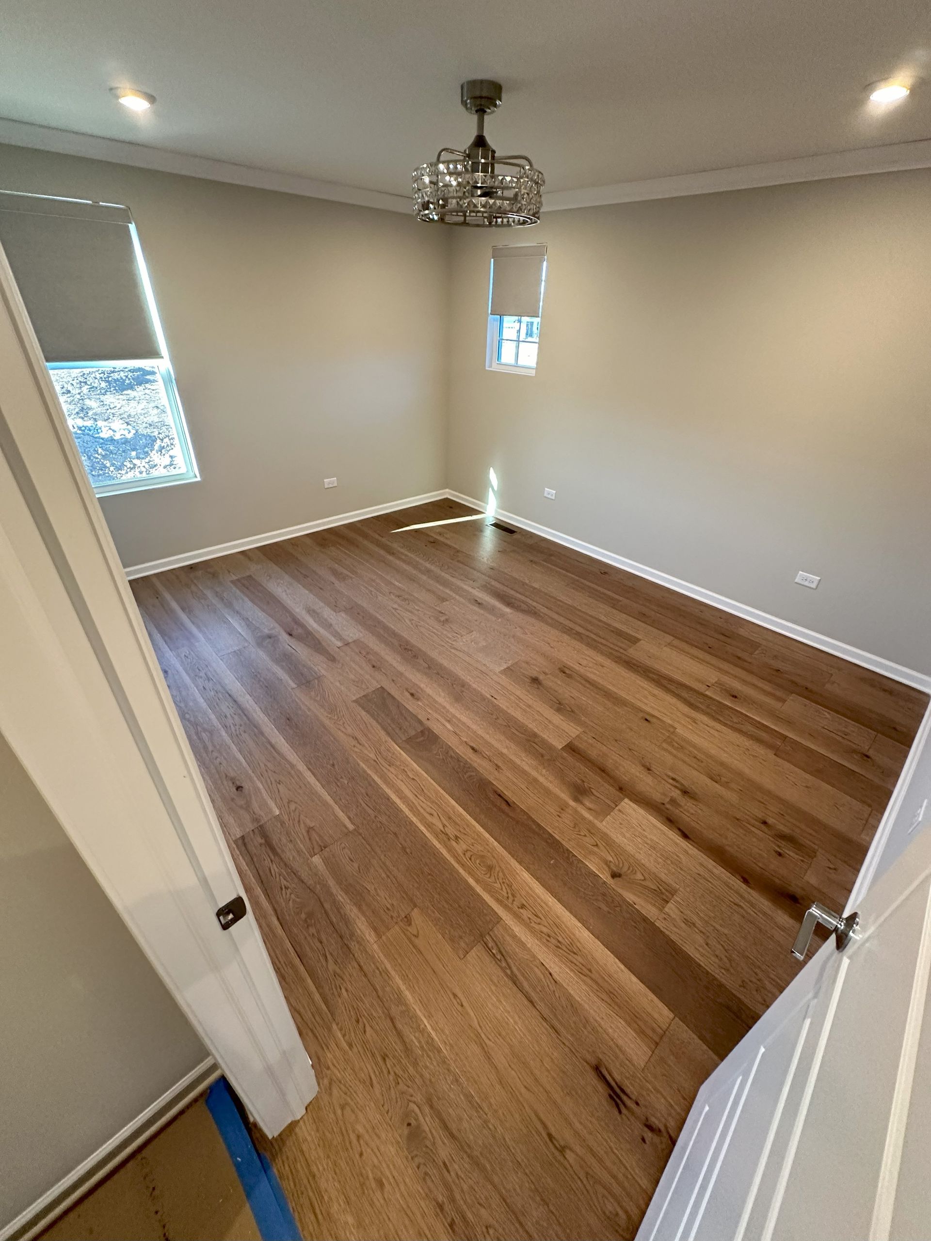 a bedroom with hardwood floors and a ceiling fan .