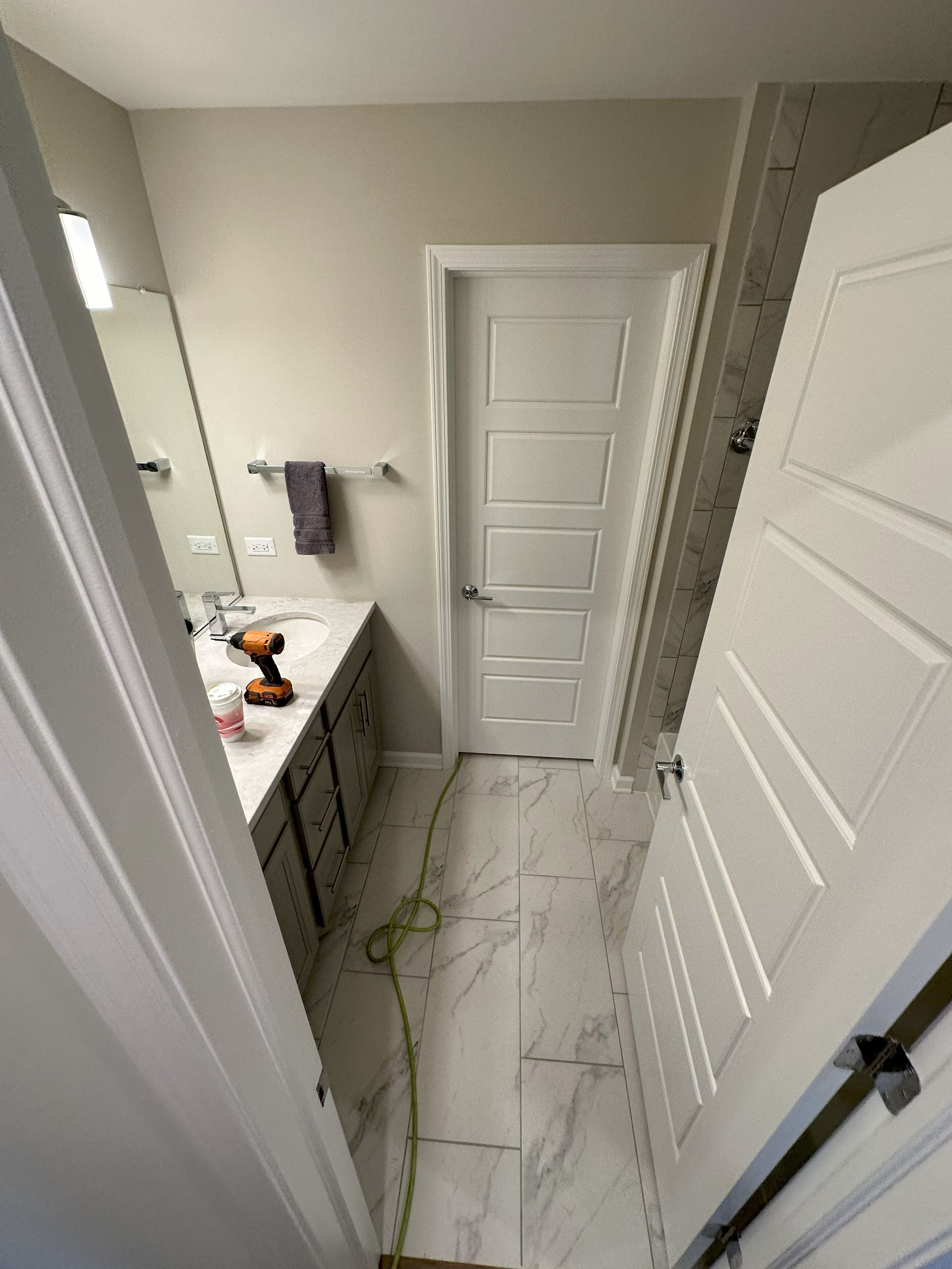 a bathroom with a sink , mirror , and door .