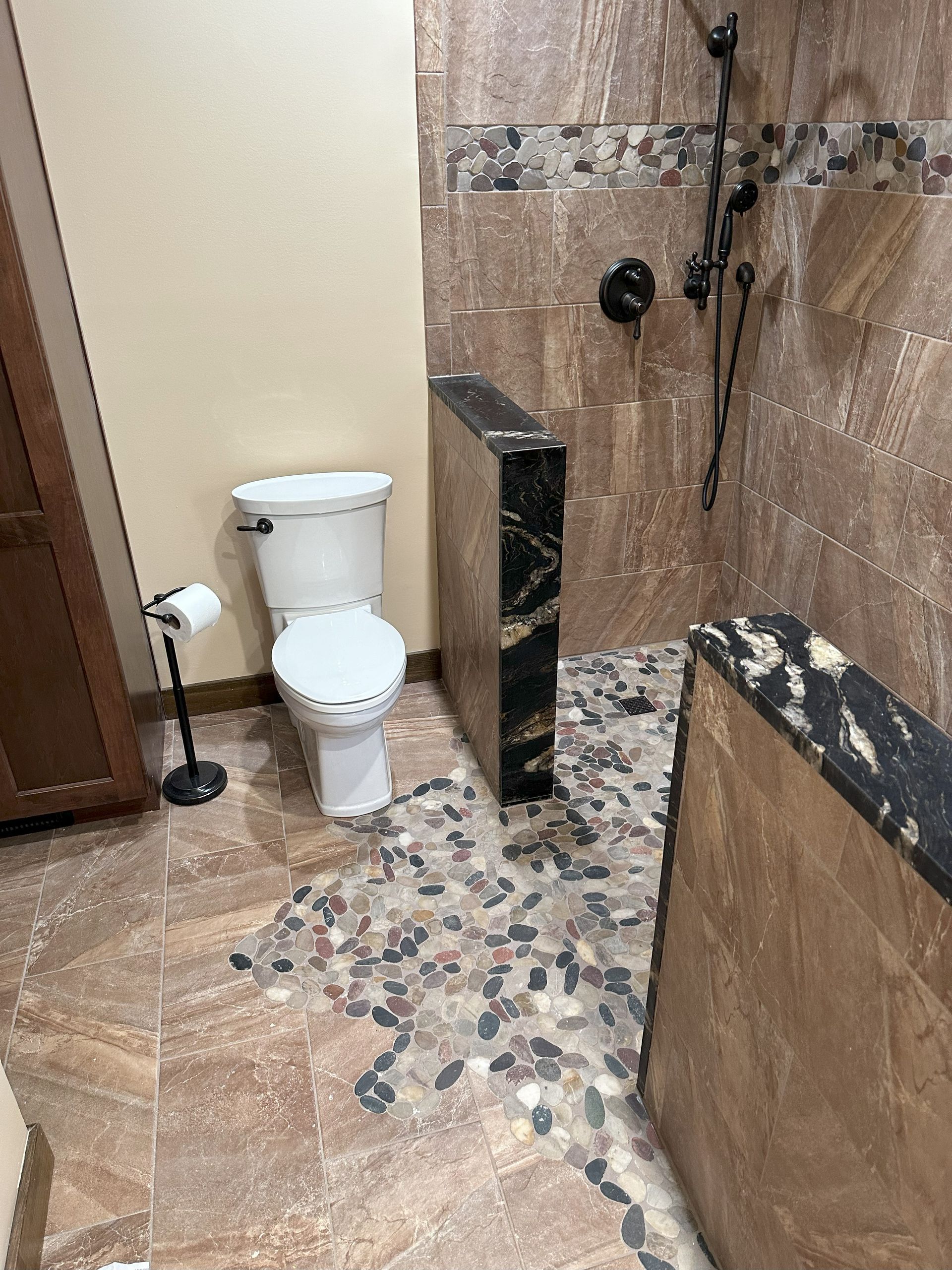 a bathroom with a toilet and a walk in shower .