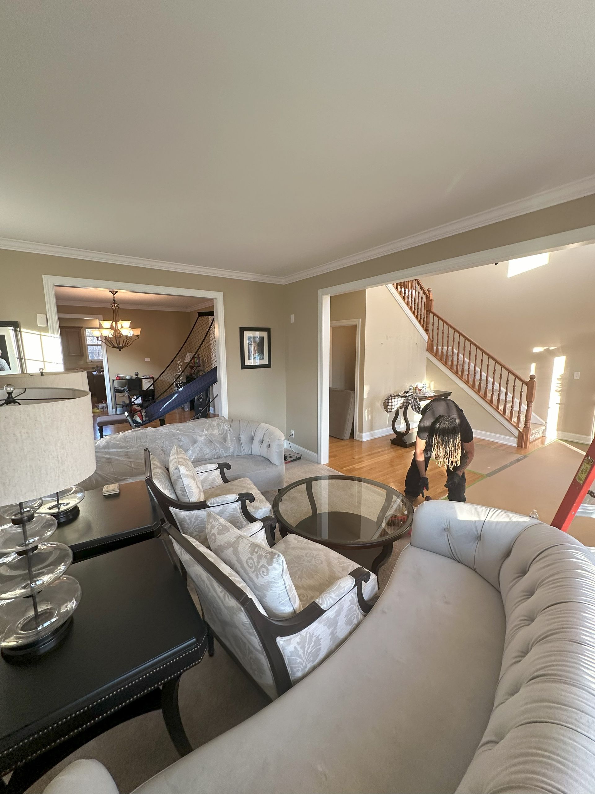 a living room with a couch , chairs , table and lamp