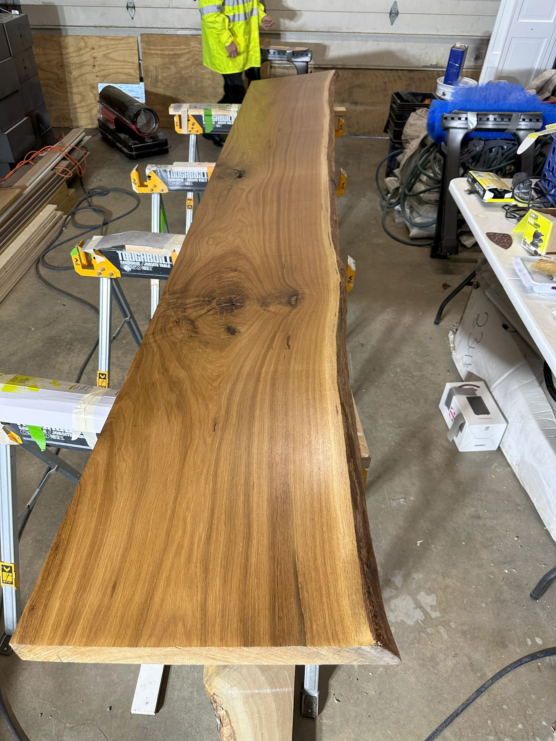 a large piece of wood is sitting on top of a table in a garage .