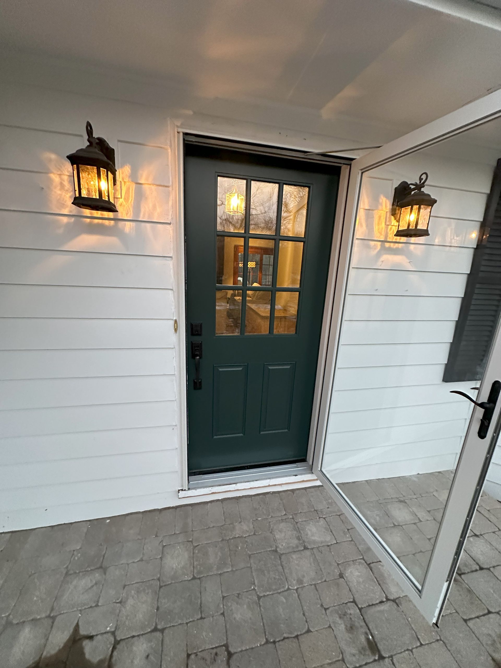 a green door is sitting on the side of a white house .
