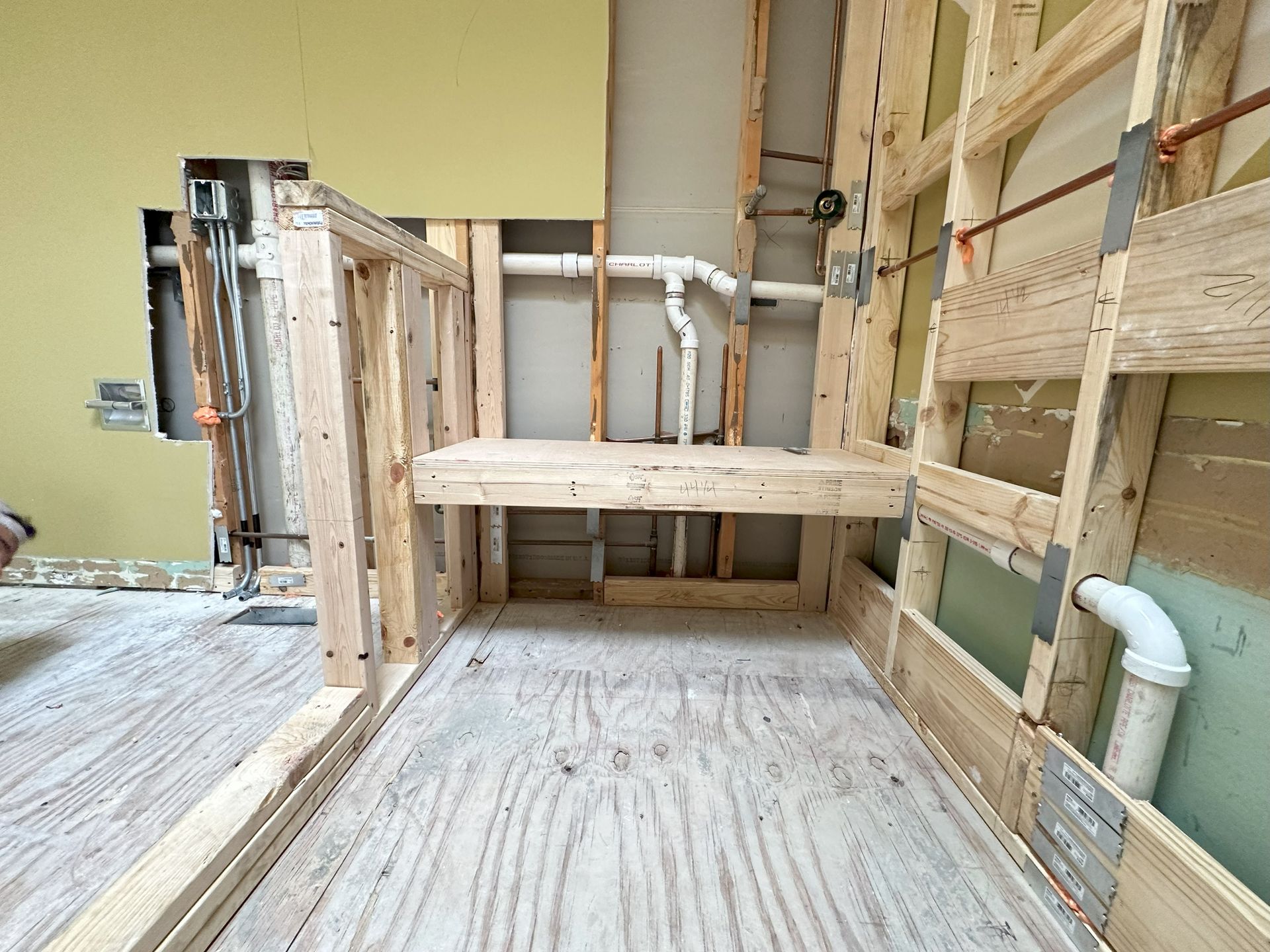 a bathroom under construction with wooden beams and pipes .