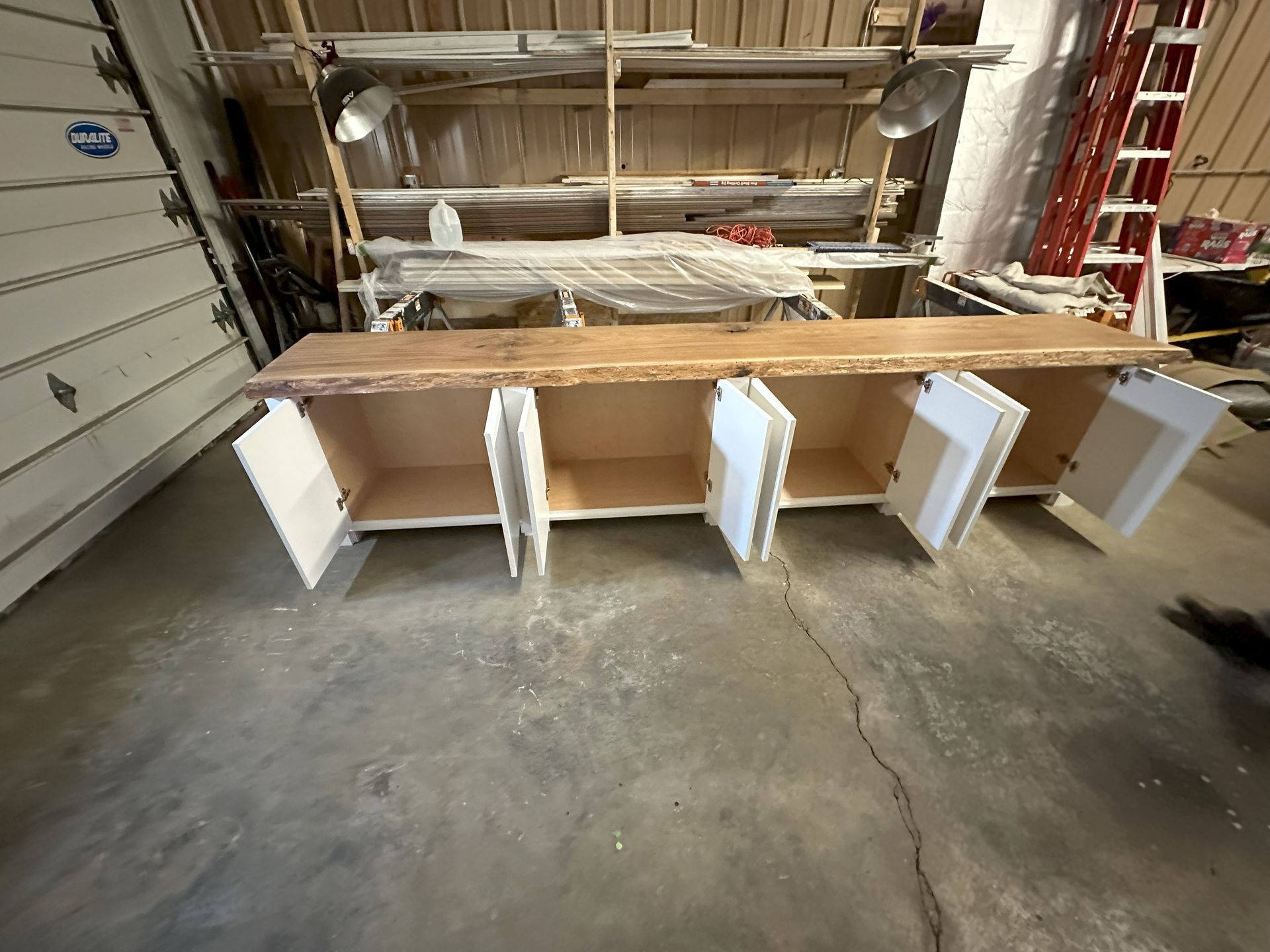a wooden cabinet with the doors open in a garage .