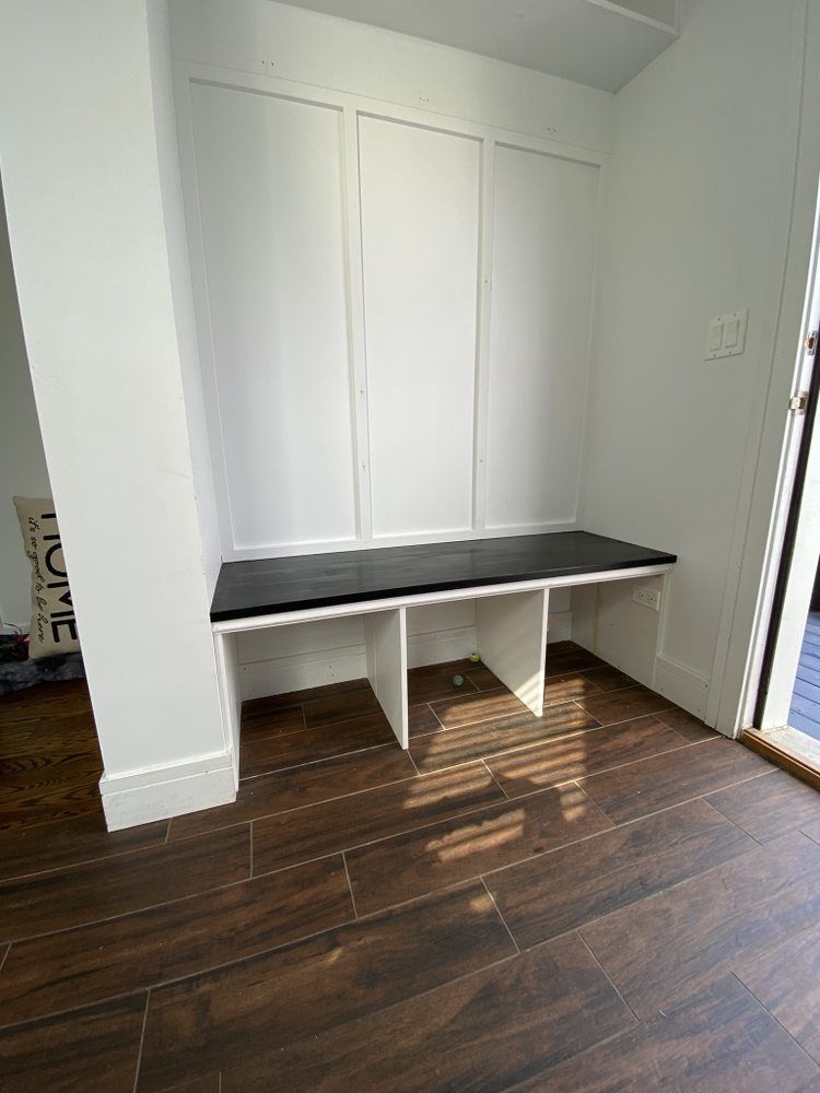 there is a bench in the corner of the room .