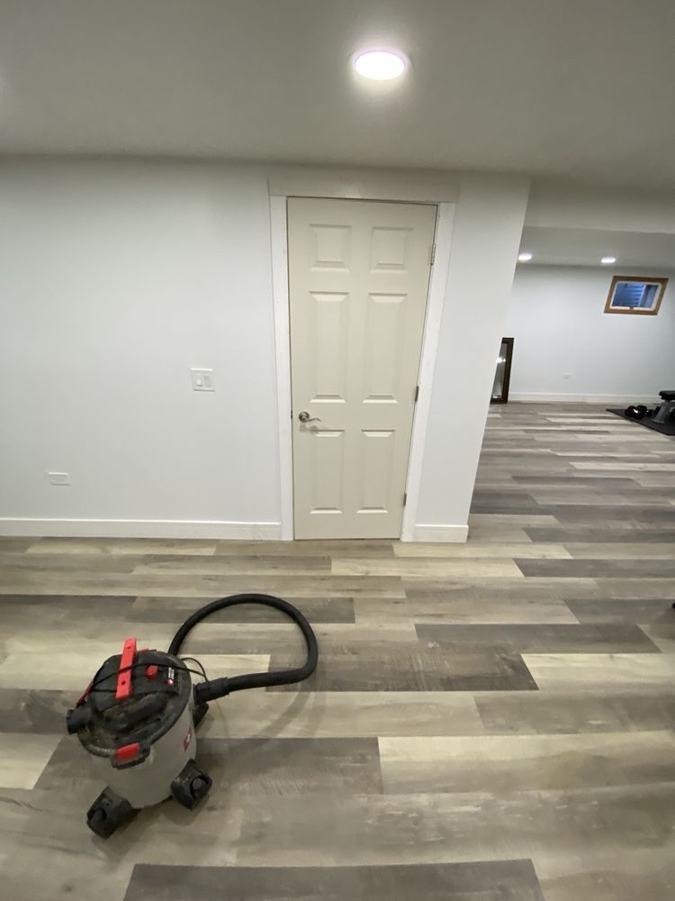 a vacuum cleaner is sitting on a wooden floor in a basement .
