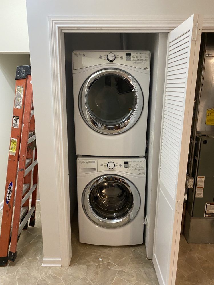 a washer and dryer are stacked on top of each other in a closet .